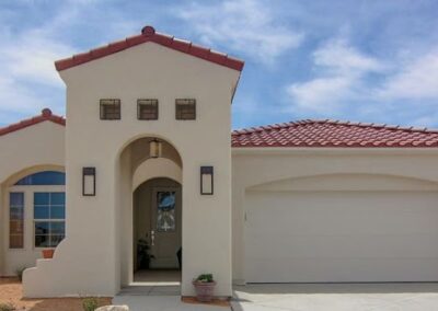 New suburban house with red tile roof and arched entryway.