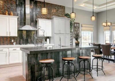 Modern kitchen interior with bar stools and pendant lights.