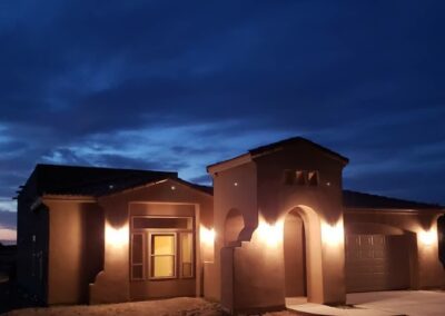 Modern Pueblo custom home in Las Cruces showcasing warm tones, arched entryways, and classic stone elements.